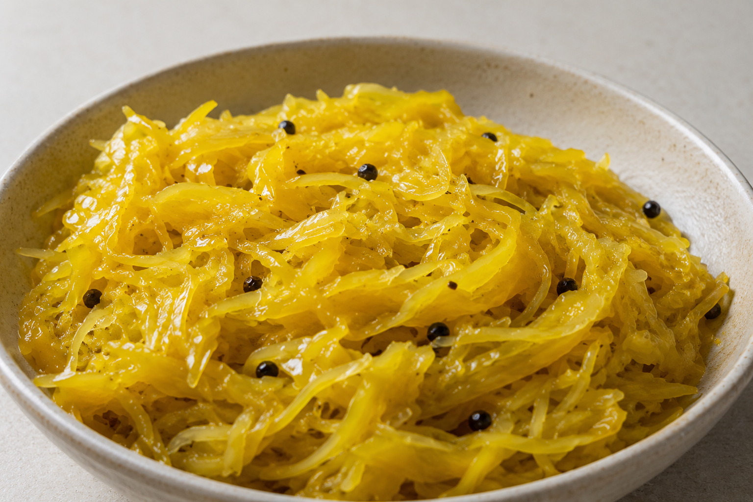 Golden turmeric-fermented cabbage with peppercorns in a ceramic bowl